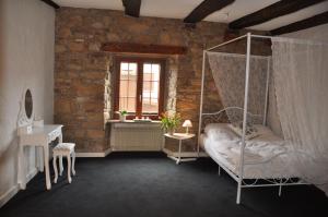 a bedroom with a canopy bed and a window at Maison de Charme "Le Moulin d'Hagenthal" - Chambre Romantique in Hagenthal-le-Bas