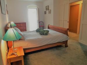 a bedroom with a bed with a lamp and a table at Old School House in Bury Saint Edmunds