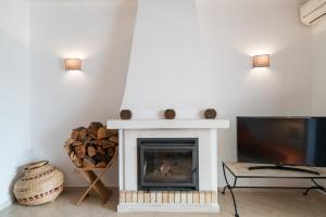 a living room with a fireplace and a tv at Alto Golf Sea Oceanview in Alvor