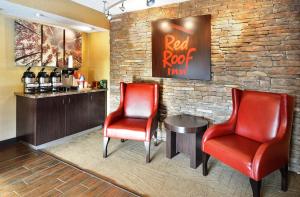 a bar with two red chairs and a table at Red Roof Inn Lexington South in Lexington