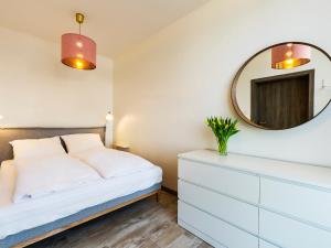 um quarto com uma cama branca e um espelho em VacationClub – 5 Mórz Sianożęty Apartament 1K/1 em Sianozety