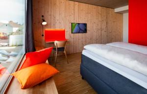 a bedroom with a bed and a chair and a window at Hotel & Restaurant Zur Glocke in Höchstädt an der Donau