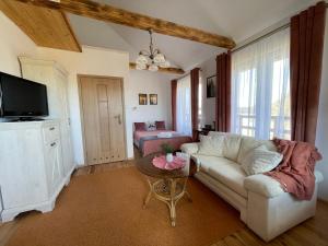 a living room with a white couch and a tv at Dolina Sarenek in Sejny