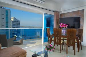 a living room with a dining table and a large window at Poseidon Lake Apartments in Cartagena de Indias