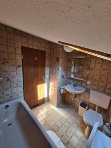 a bathroom with a tub and a toilet and a sink at Alpenpension Bergidyll in Schönau am Königssee