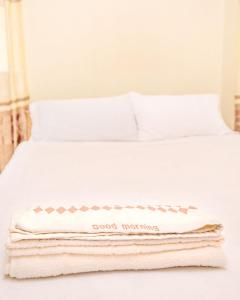 a white bed with a good morning blanket on it at Camotes Eden in Himensulan