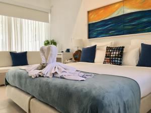 a bedroom with a bed with a dress and a painting at Casa Veintiuno in Sosúa +37 photos
