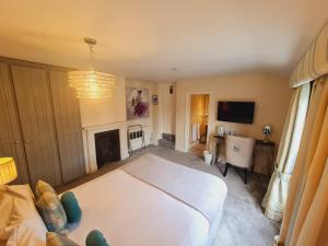 1 dormitorio con cama blanca y chimenea en Beaufort Lodge, en Taunton