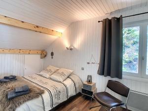 una camera con un letto e una sedia e una finestra di Mont Étape , F2, 42 m2, Calme, Vue Mt Blanc a Passy