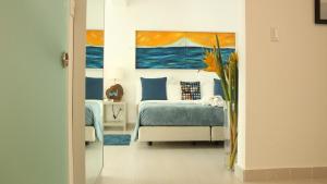 a bedroom with a bed and a painting of the ocean at Casa Veintiuno in Sosúa