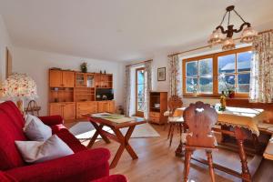 ein Wohnzimmer mit einem roten Sofa und einem Tisch in der Unterkunft Ferienhaus Zechmeister in Schönau am Königssee