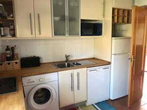 a kitchen with a sink and a washing machine at Chale a 25 minutos de Madrid cerca de Somosierra in El Casar de Talamanca