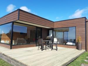 Casa con terraza con mesa y sillas en Cabañas Vista Volcanes del Sur, en Llanquihue