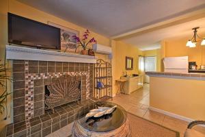 a living room with a fireplace with a tv above it at Lido Key Hideout with Patio and Yard and Walk to Beach! in Sarasota