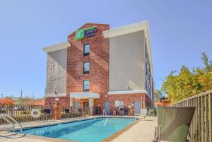 a hotel with a pool in front of a building at Holiday Inn Express Hotel & Suites Gulf Shores by IHG in Gulf Shores