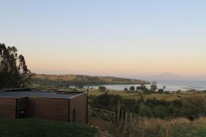 a house on a hill with a view of the water at Cabañas Vista Volcanes del Sur in Llanquihue