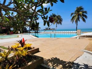 a swimming pool with the ocean in the background at Tanjung Tuan Beach Regency - Hermis Theme 1 Car Park in Kampong Baharu