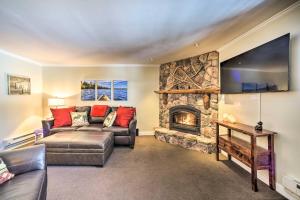 a living room with a couch and a fireplace at Cozy Condo by Mirror Lake, 1 Block to Downtown! in Lake Placid