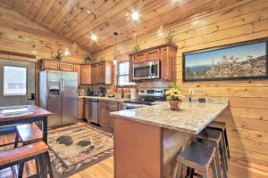 a large kitchen with wooden cabinets and a large window at Rustic Pigeon Forge Cabin with Hot Tub Near Town! in Pigeon Forge