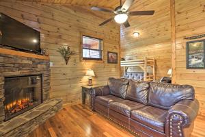 a leather couch in a living room with a fireplace at Rustic Pigeon Forge Cabin with Hot Tub Near Town! in Pigeon Forge