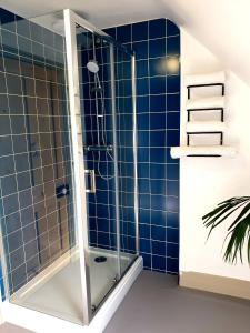 um chuveiro numa casa de banho com azulejos azuis em Upper Rooms Seaford em Seaford