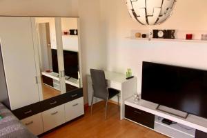 a living room with a desk and a television at Big and Beautiful in Hannover