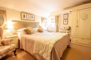 um quarto com uma cama grande e uma cadeira em The Tankerville Arms em Eglingham