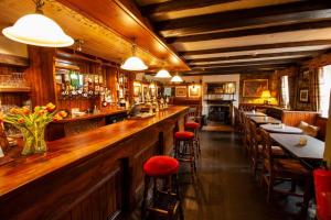 a bar with tables and stools in a restaurant at The Tankerville Arms in Eglingham