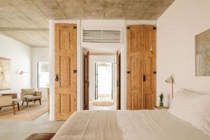 a bedroom with a large bed and wooden doors at Hospedaria in Alvisquer +63 photos