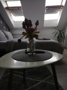 a living room with a table with a vase of flowers at Apartment Centrum - Free private parking in Novi Sad