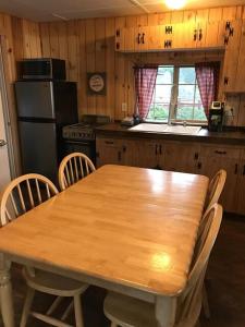 eine Küche mit einem Holztisch mit Stühlen und einem Kühlschrank in der Unterkunft Mercer Lake Resort and Private Beach in Florence