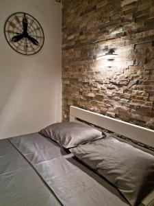 a bedroom with a bed and a brick wall at Apartment Amfiteatar in Pula
