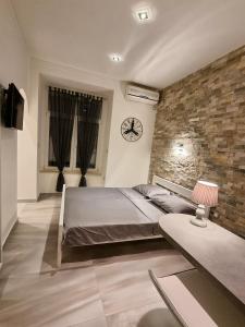 a bedroom with a bed and a brick wall at Apartment Amfiteatar in Pula