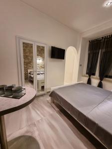 a bedroom with a bed and a table and a television at Apartment Amfiteatar in Pula
