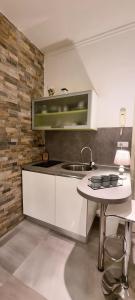 a white kitchen with a sink and a table at Apartment Amfiteatar in Pula
