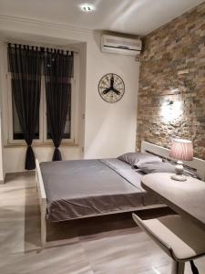 a bedroom with a bed and a clock on the wall at Apartment Amfiteatar in Pula
