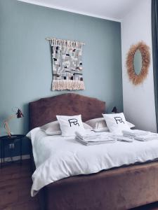 Una cama con sábanas blancas y almohadas con la palabra fija en Rost Apartments, en Bielsko-Biala