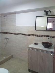 baño con lavabo y espejo en la pared en Villa Leandro en Mina Clavero