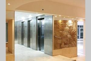 a row of elevators in a building with a stone wall at Cabo Corrientes - Mar del Plata - Preguntar antes de reservar in Mar del Plata