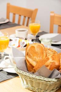 einen Tisch mit einem Korb Brot und Orangensaft in der Unterkunft Hotel-Klanxbüller-Stuben in Neukirchen