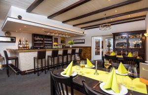 ein Restaurant mit Tischen und Stühlen und eine Bar in der Unterkunft Hotel-Klanxbüller-Stuben in Neukirchen