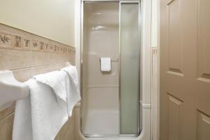 a glass shower in a bathroom with towels at Super 8 by Wyndham Niagara Falls by the Falls in Niagara Falls +21 photos
