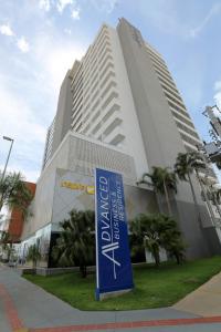 un bâtiment avec un panneau bleu devant lui dans l'établissement Advanced Hotel & Flats Cuiabá, à Cuiabá