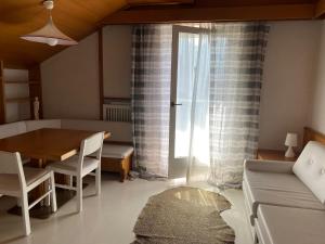 a small living room with a table and a couch at Villa Del Rosensuite in Pinzolo
