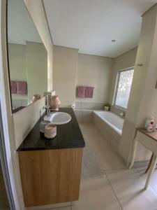 a bathroom with a sink and a bath tub at 504 The HeroldsBay in Herolds Bay