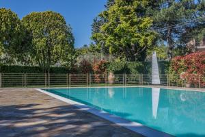 a swimming pool with a fountain in the background at Residence Oasi in Manerba del Garda