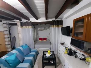 a living room with a blue couch and a bed at Apartment The old house in Vrsar