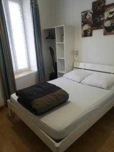 a bed with a black blanket on it in a bedroom at VILLA DUCHATEL in Le Mont-Dore