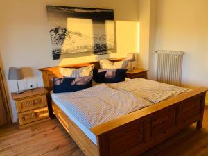 una camera da letto con un grande letto in legno con cuscini blu di REIT IM WINKL - ValleyViewInn a Reit im Winkl