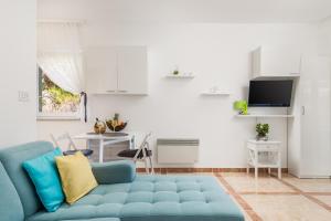 een woonkamer met een blauwe bank en een tafel bij Blue Dream Studio Apartment with a pool in Opatija